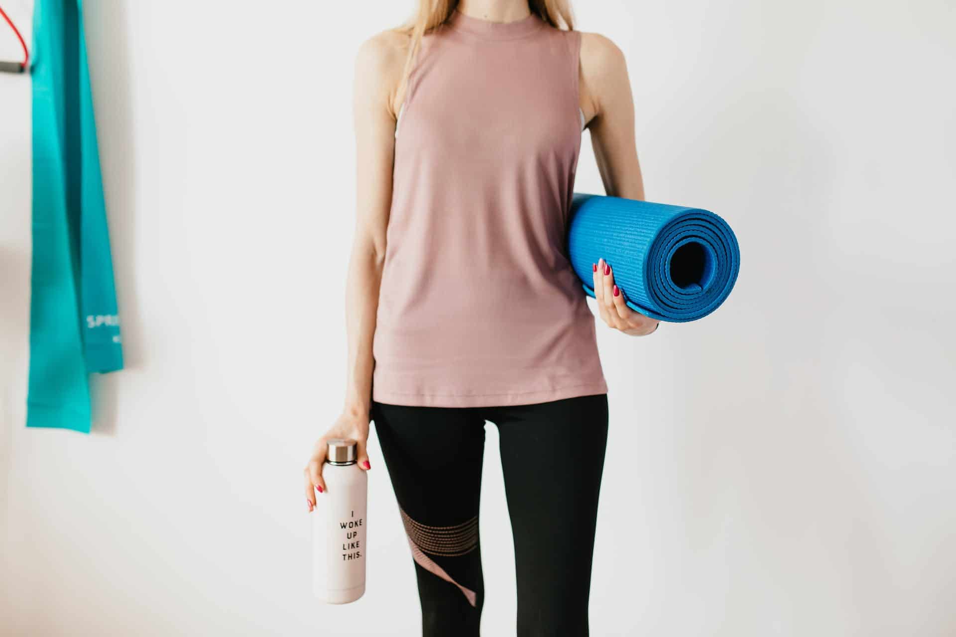 A girl standing with gym accessories