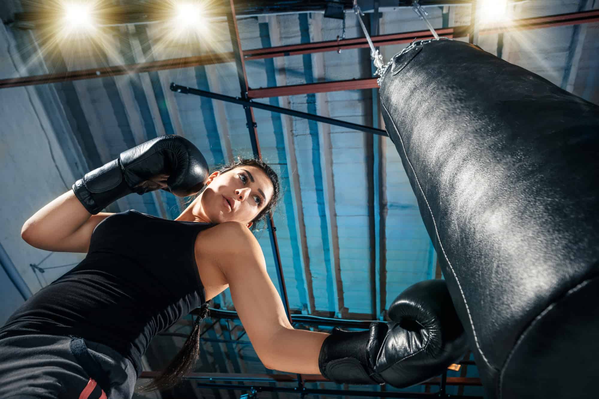 female boxer training with punching bag